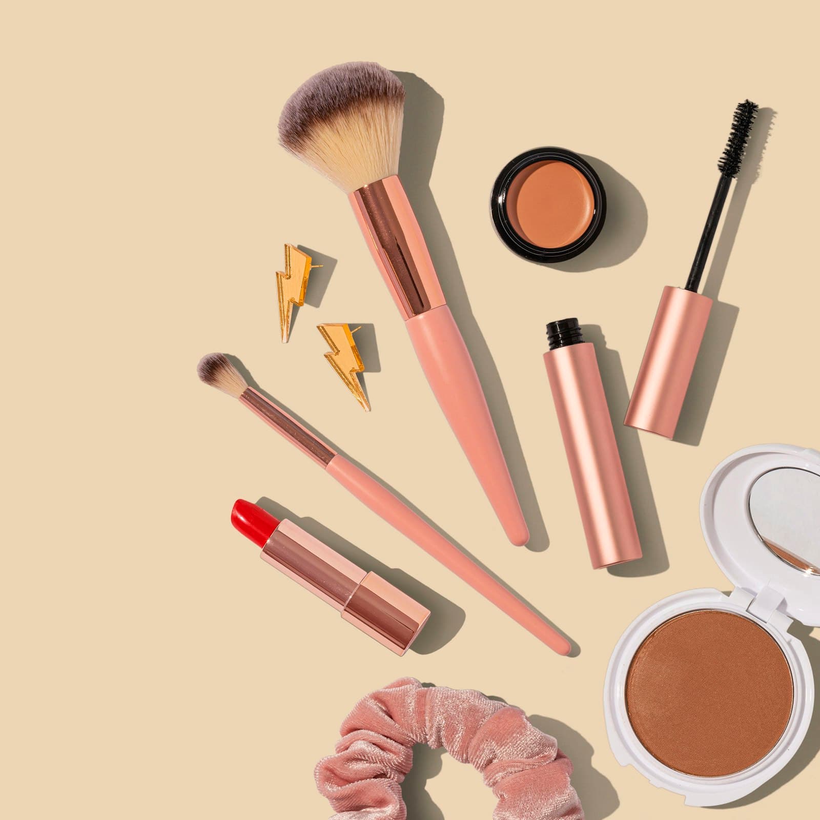 Makeup brushes, lipstick, and powder arranged as a beauty still life.